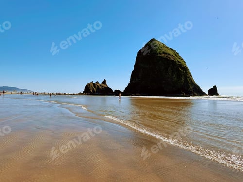 Preview: two stacks of rocks at the shore line of the beach
