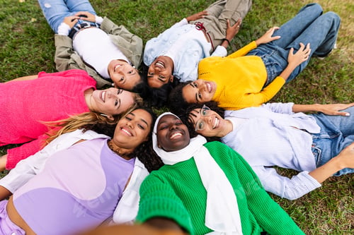 Preview: Happy group of women lying on circle on grass taking selfie portrait at park.