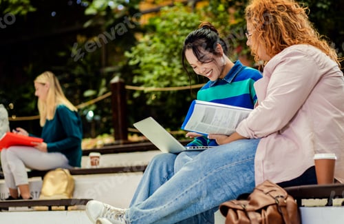 Preview: Diverse group of student siting in campus learning together.