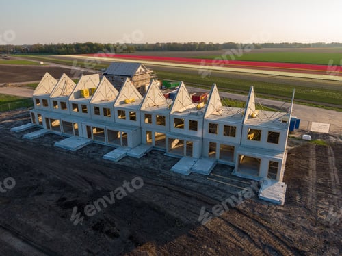 Preview: Aerial shot of constructed buildings with a beautiful view of a field during sunset
