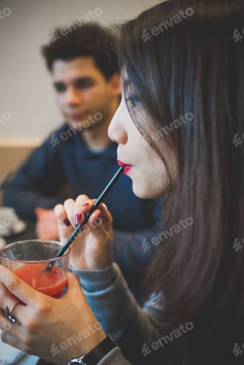 Preview: close up of young woman drinking orange juice