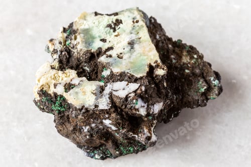 Preview: raw tenorite mineral with chrysocolla on white