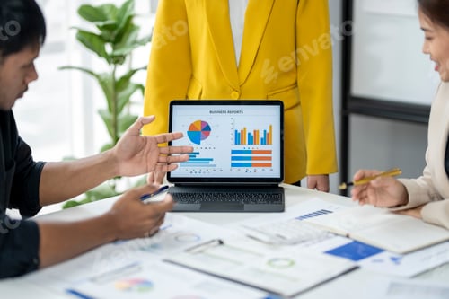 Preview: A group of people are looking at a laptop with a pie chart on it