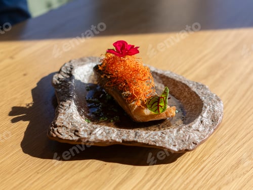 Preview: single serving of grilled salmon, adorned with orange zest, garnishes, and a single pink flower