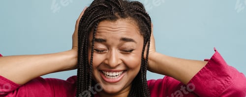 Preview: Young black laughing woman with pigtails covering her ears