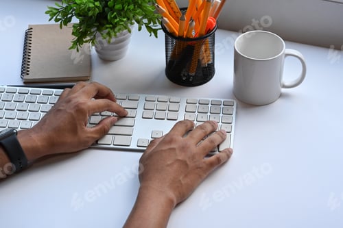 Preview: Businessman hand typing on wireless keyboard.