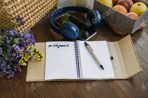 Preview: New Years Resolutions Goals motivational phrase in open notebook on the table. Outdoor still life