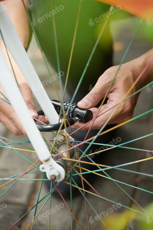 Preview: Man Putting Lock on Bicycle Wheel