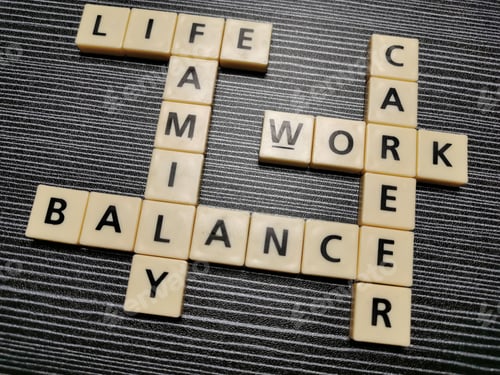 Preview: Crossword life family balance work career made from square letter tiles against black background.
