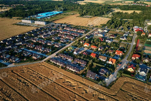 Preview: Residential houses in small town near agricultural field, aerial view