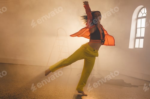 Preview: Image of biracial female modern dancer dancing in smoked interior