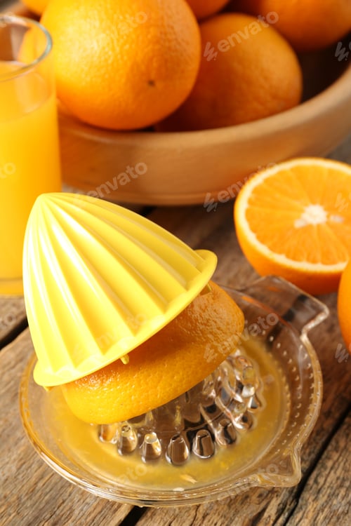 Preview: Juicer with fresh orange fruits on wooden table, closeup