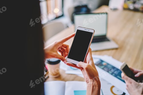 Preview: Faceless colleagues browsing cellphones in workplace