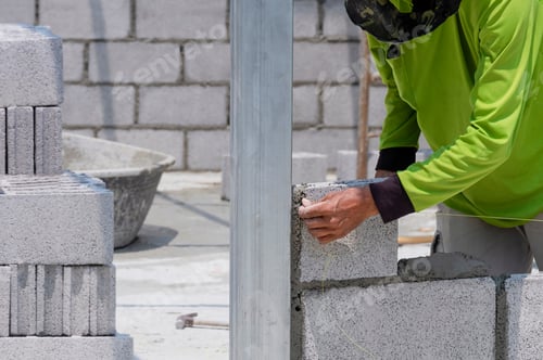 Preview: Builder worker hand setting nylon level line for building brick wall in house construction site