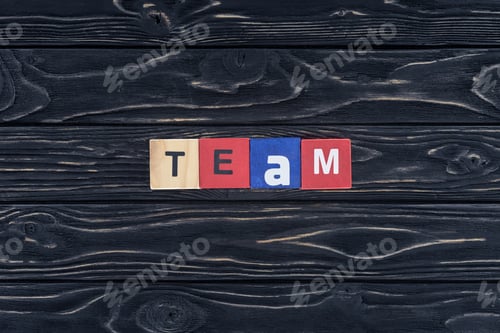 Preview: top view of word team made of wooden blocks on dark wooden tabletop