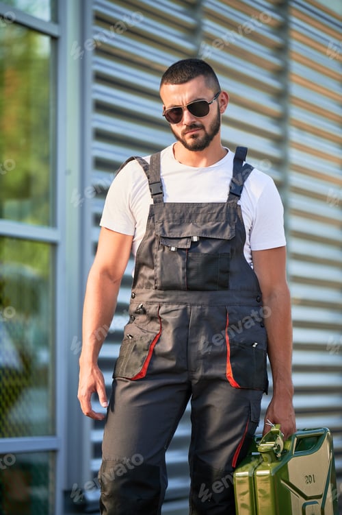 Preview: Strong gas station worker holding canister full of fuel.