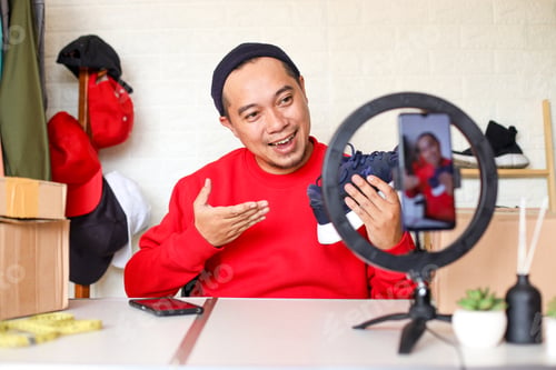 Preview: Friendly Asian man vlogger looking at camera reviewing product