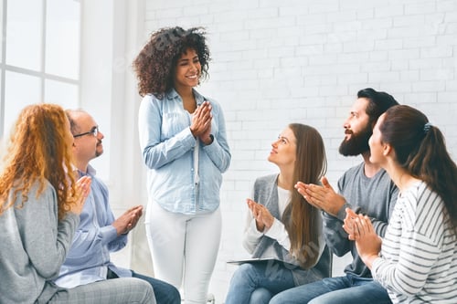 Preview: Young people clapping to woman at rehab group meeting
