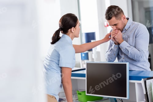 Preview: Nurse in blue uniform encouraging upset patient in clinic