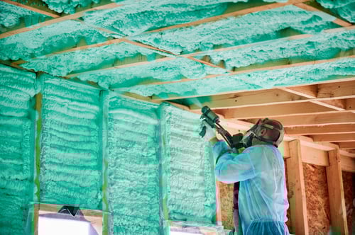 Preview: Worker spraying polyurethane foam for insulating wooden frame house.