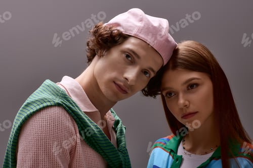Preview: Stylish young couple showcases trendy outfits in a sophisticated grey studio setting