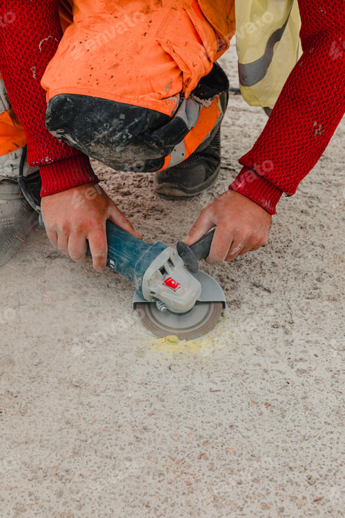 Preview: Vertical shot of hands of a worker doing concrete cutting