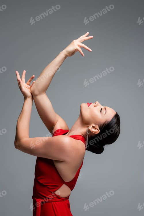 Preview: Side view of brunette woman in red dress dancing tango isolated on grey