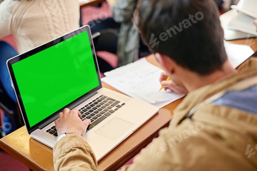 Preview: Overhead shot of a student using his laptop at his desk in class