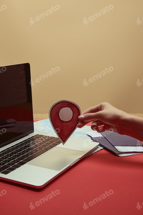 Preview: cropped image of woman holding location sign near laptop