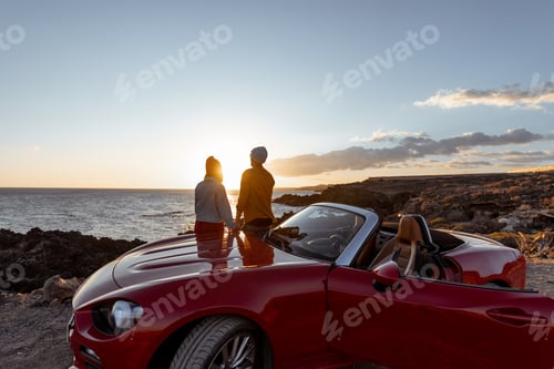 Preview: Lovely couple on the beach near the car on a sunset