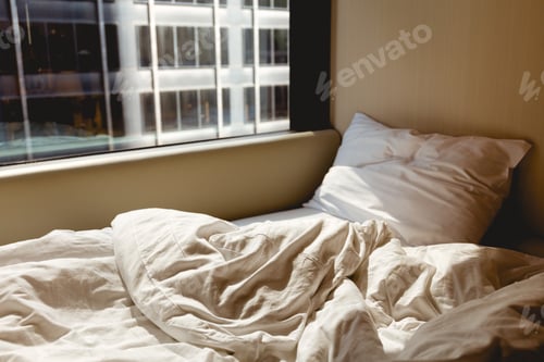 Preview: close up view of empty bed near window in hotel room