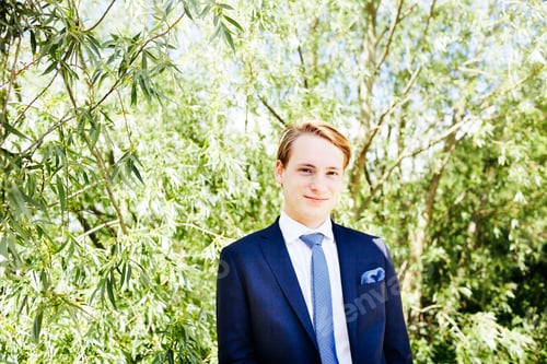 Preview: Portrait of handsome graduate standing at university park