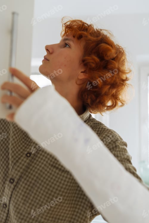 Preview: teenage girl, with cast on arm, cook lunch at home