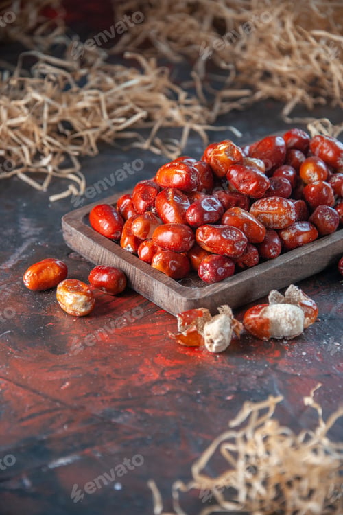 Preview: Half shot of fresh raw silverberry fruits inside and out side of a wooden tray on mix colors