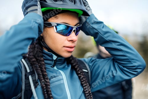 Preview: Female mountain biker standing on road outdoors in winter