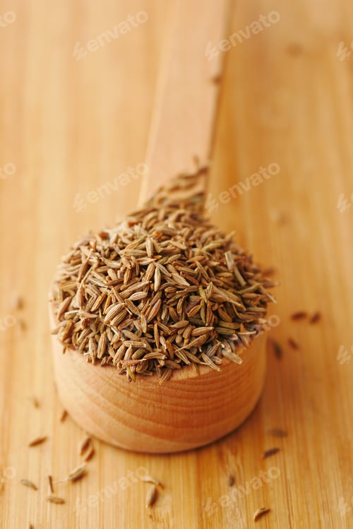 Preview: cumin seeds on spoon on table , close up