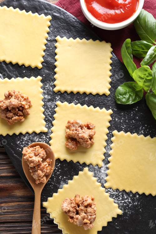 Preview: Making ravioli bolognese at wooden table, flat lay