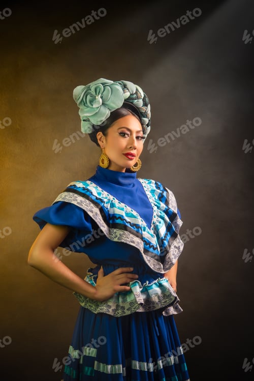 Vista previa: Una mujer con un vestido azul y una diadema de flores posa para una foto