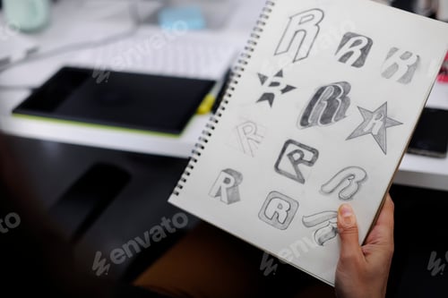 Preview: Hand Holding Notebook With Drew Brand Logo Creative Design Ideas