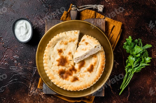 Preview: Meat pie Kubdari, Tasty Georgian Flat Bread Stuffed with meat. Dark background. Top view