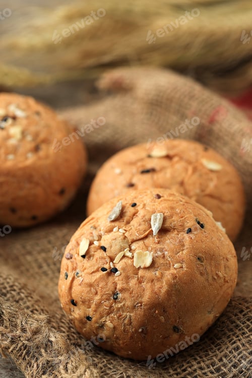 Preview: Round Burger Bun with Ceral and Seeds Topping Above Rustic Jute Fabric
