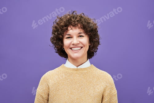 Preview: Young laughing woman with shoert curly brown hair looking at camera