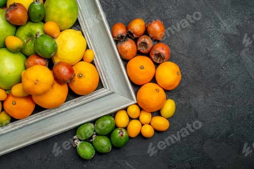 Preview: Half shot of collection of fresh fruits in picture frame and around it on dark background