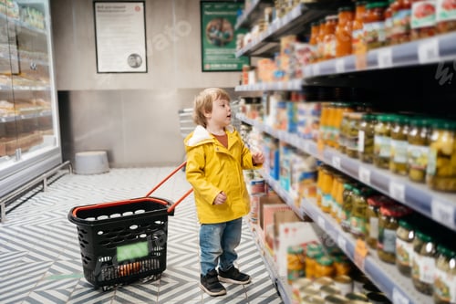 Preview: child in the market carries a cart for groceries, chooses a product, shopping day