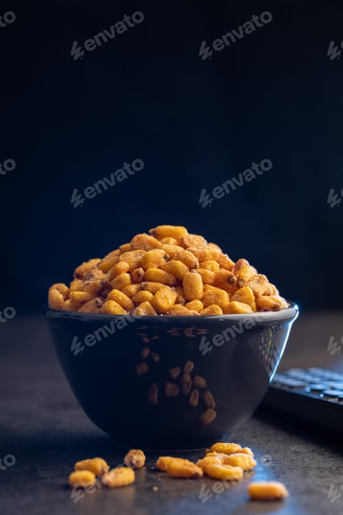 Preview: Roasted salted corn snack in bowl on black table.