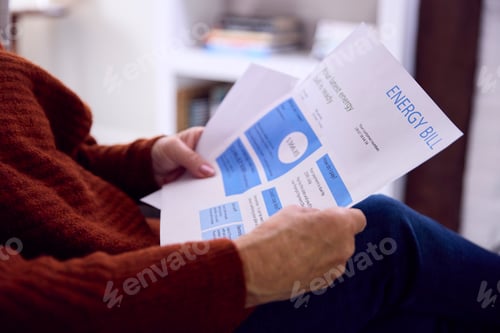 Preview: Close Up Of Senior Woman At Home Looking At USA Energy Bill During Cost Of Living Energy Crisis
