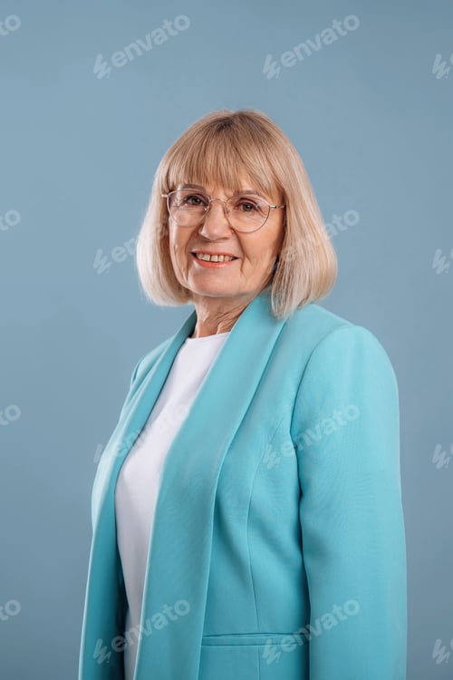 Preview: Senior businesswoman in glasses is standing against background