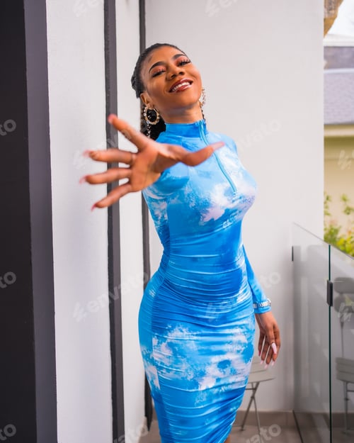 Preview: Fashion lifestyle of a black ethnic girl with collected hair and a blue dress