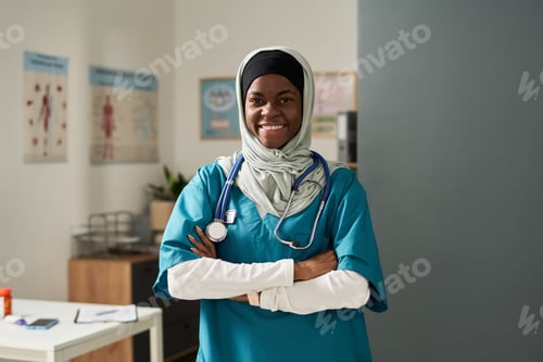 Preview: Smiling Muslim Nurse Standing in Medical Office Setting