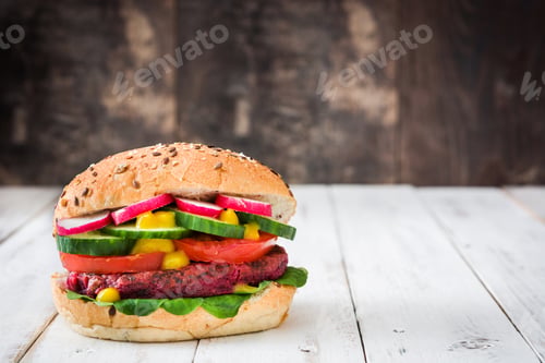 Preview: Healthy beetroot burger with fresh vegetables and mustard, lying on a white wooden table